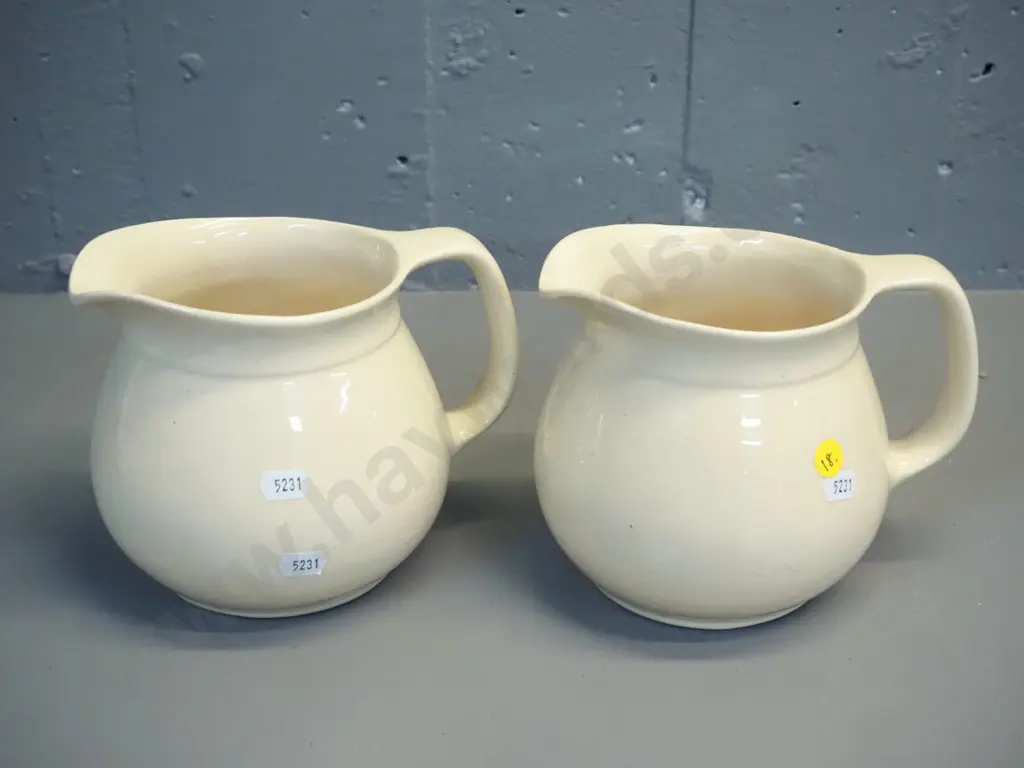 2 early Crown Lynn cream glaze milk jugs - one with tiki mark, both stamped 709-3. Some crazing. H-140 W-170 at handle Image 1++
