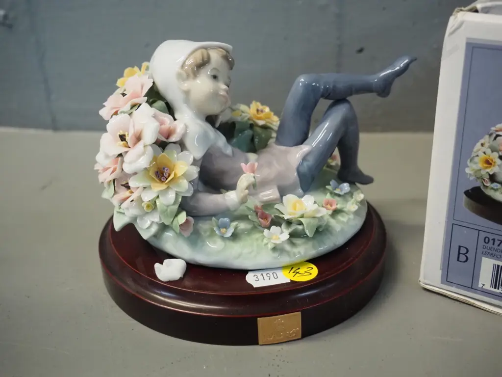 Lladro figure of pixie reclining in flowers, 1 leaf chipped off. H100 L130, comes with composite base & original box Image 1++