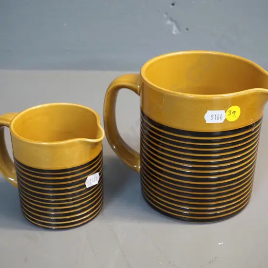 2 T&G Greene fine stripe gold and black jugs, larger is H-130 W-160