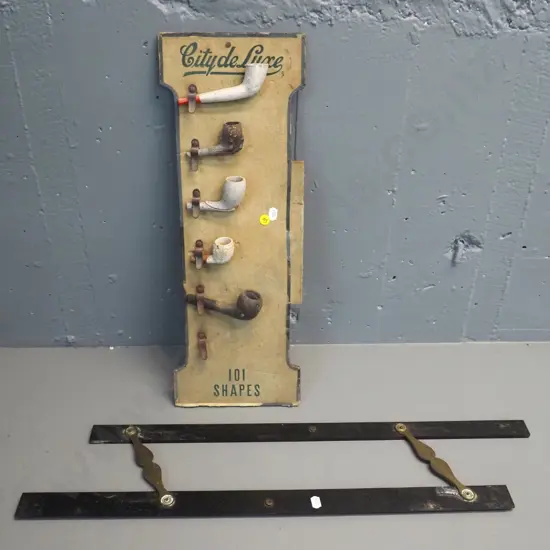 clay pipes and part pipes on vintage pipe retail display board and a vintage timber and brass parallel rule L610