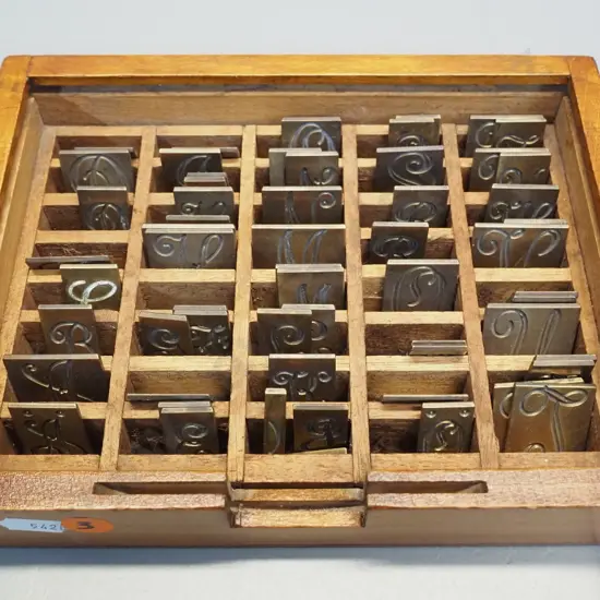 set of brass engraved letter pieces in wooden box with dividers, no lid - box is H-50 W-200 D-150
