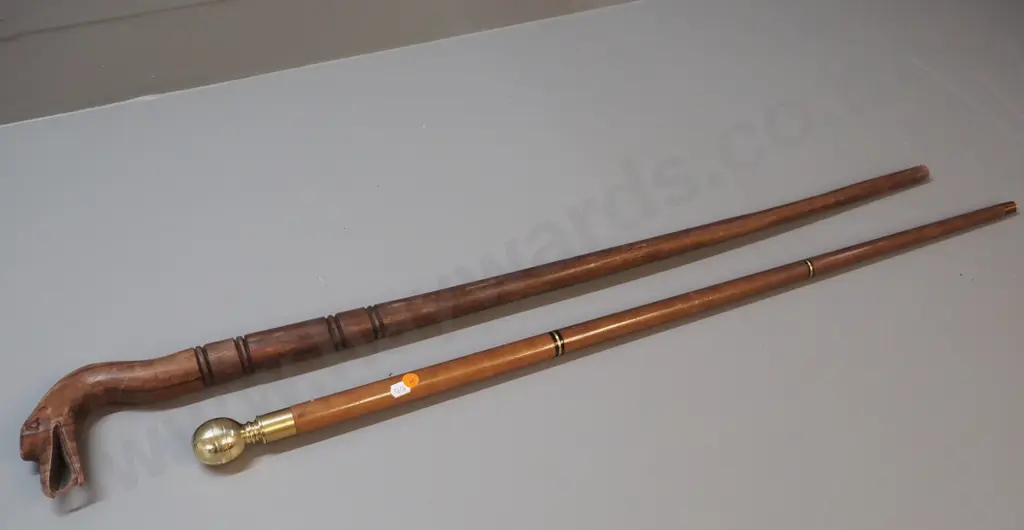 2 walking sticks - carved wood with bird motif head and a brass, other wood with glass vial under screw-top knob Image 1++