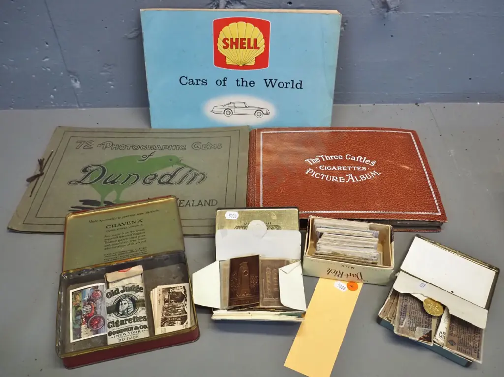 3 Castles cigarette card album, assorted loose cards in tobacco tins, Shell Cars of the World album and Dunedin Image 1++