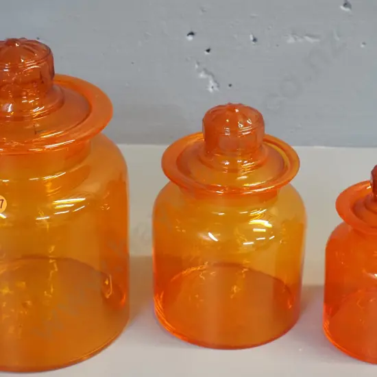 graduated set of 3 orange glass stoppered storage jars - largest is H-250 D-160