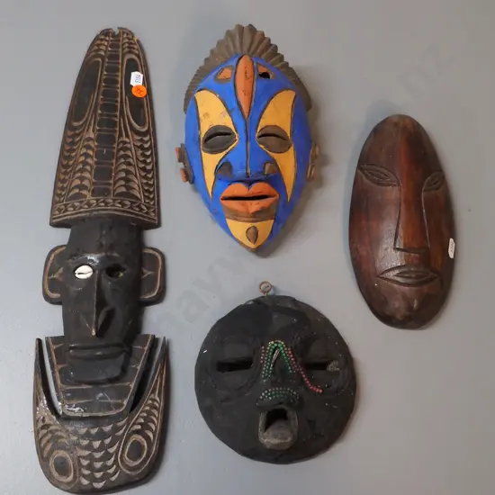 4 wall masks - 3 carved timber, 1 pottery, some damage, wear, missing shell decoration etc. Largest H430