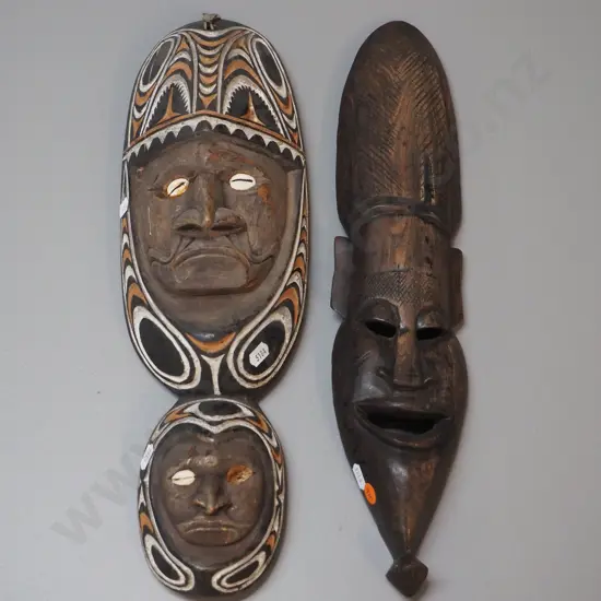 2 carved wooden wall masks - one with shell & painted design, one missing shell. Larger is H-450 W-140