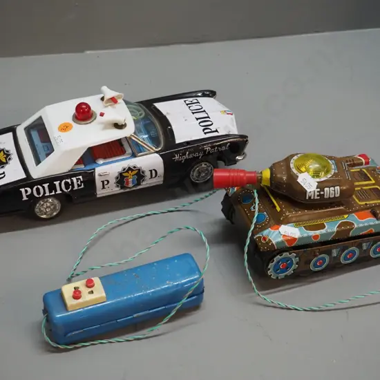2 battery operated tin toy vehicles - Banda Japan police car H90 L280 & tank with wired remote control - both untested,