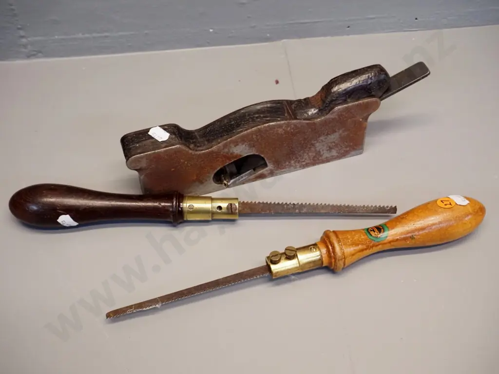 3 hand tools - corroded steel and wood plane and 2 brass and wood-handled keyhole saws Elliot Lewis Elvicta Image 1++