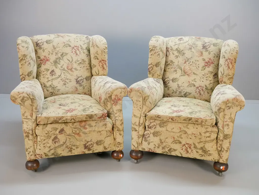 pair of vintage chesterfield style rolled-arm wing-back lounge chairs w/ ball feet, metal casters, covered in floral Image 1++