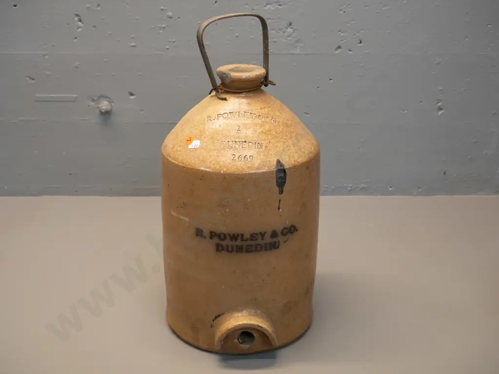 narrow-mouth crock with metal handle, marked R Powley & Co Dunedin 2669, chip to rim. No tap. H460 D220 Image 1++