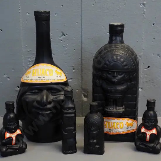 Huaco Italian brandy in figural black glass bottles - two 750ml bottles and 4 miniatures, sealed with contents