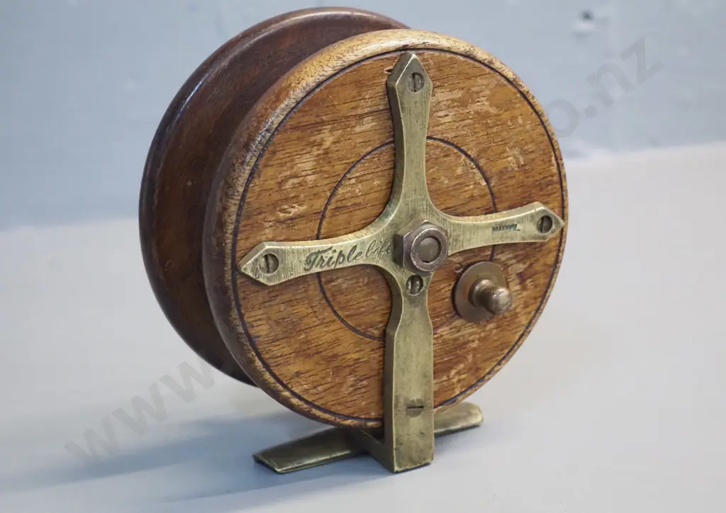 timber and brass fishing reel marked Heatons Triple Life - w/bakelite knobs. Diameter 115 Image 1++