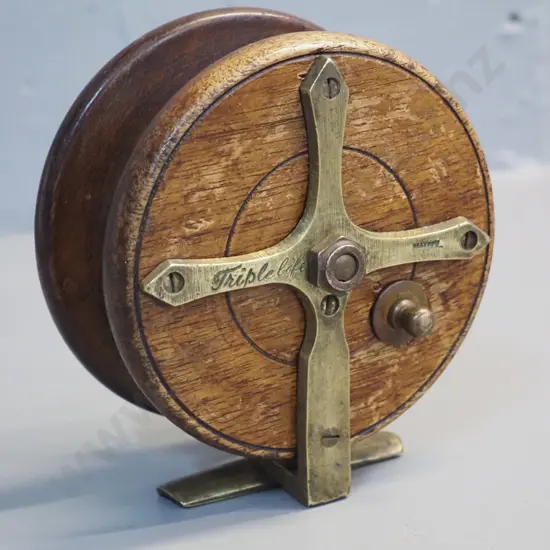 timber and brass fishing reel marked Heatons Triple Life - w/bakelite knobs. Diameter 115