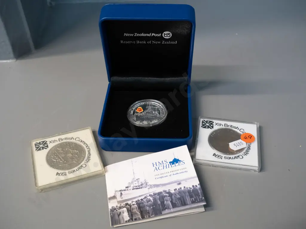 cased 2014 HMS Achilles commemorative silver proof dollar and two 1974 NZ Commonwealth Games Image 1++