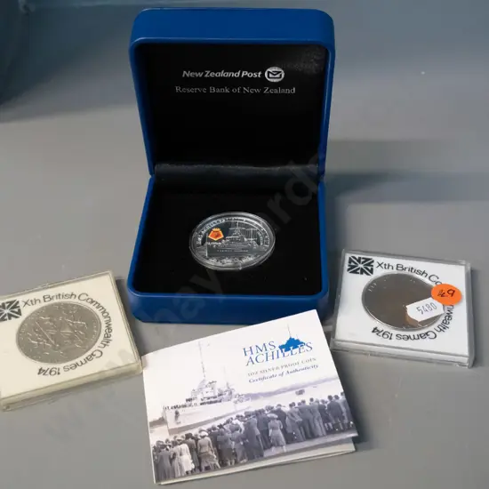 cased 2014 HMS Achilles commemorative silver proof dollar and two 1974 NZ Commonwealth Games