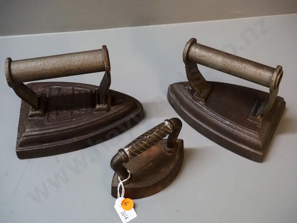 3 cast iron items - 2 sad irons - one unmarked, one Silvesters H120 L170 and a collar & cuff iron, no maker's mark Image 1++