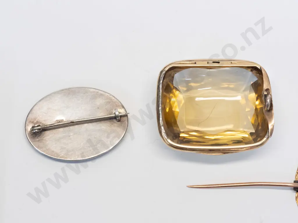 2 vintage brooches - onyx in sterling silver mount, and clear yellow faceted item in gold mount - clasp has come off Image 1++