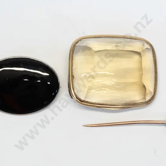 2 vintage brooches - onyx in sterling silver mount, and clear yellow faceted item in gold mount - clasp has come off