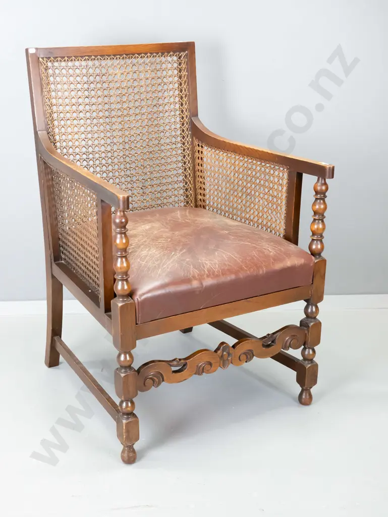 oak-framed Tudor style occasional chair with bergere cane back and sides, leather upholstered seat, carved front rail. Image 1++