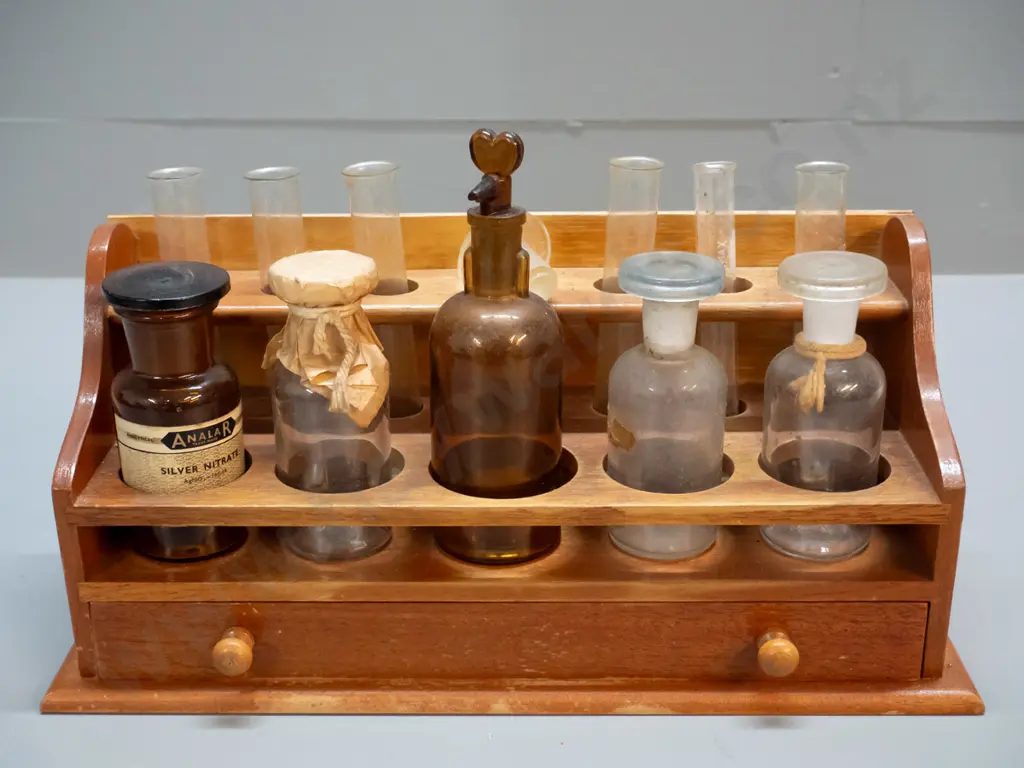 vintage wooden chemist's stand with assorted bottles, test tubes, and mineral samples in drawer Image 1++