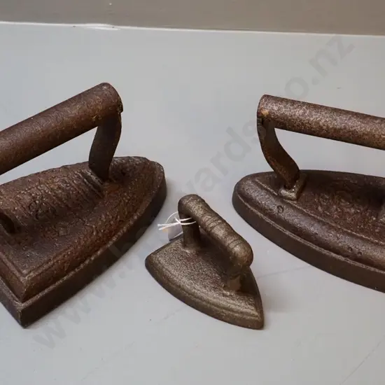 3 cast iron items - 2 sad irons and a collar & cuff iron, no maker's mark - unreadable marks, larger is