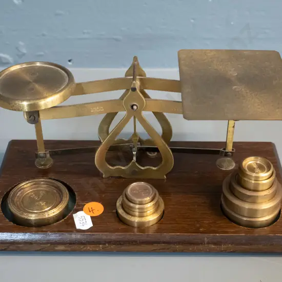 small set of brass balance scales on wooden base, with 10 weights - marked Made in England - Warranted Accurate H90 W215