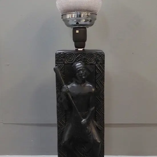 black painted plaster table lamp with Maori warrior relief motif, textured glass with chrome lamp holder. Chip to finish
