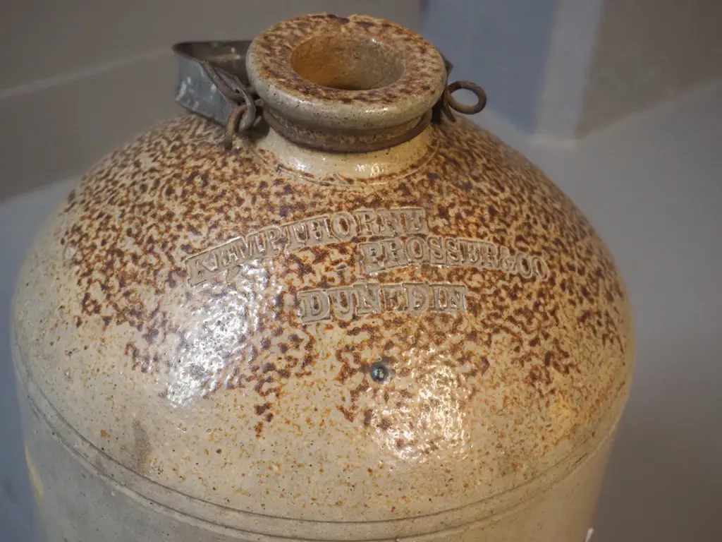narrow-mouth stoneware crock with metal handle - marked Kempthorne Prosser Dunedin - small chip to mouth H-370 D-210 Image 1++