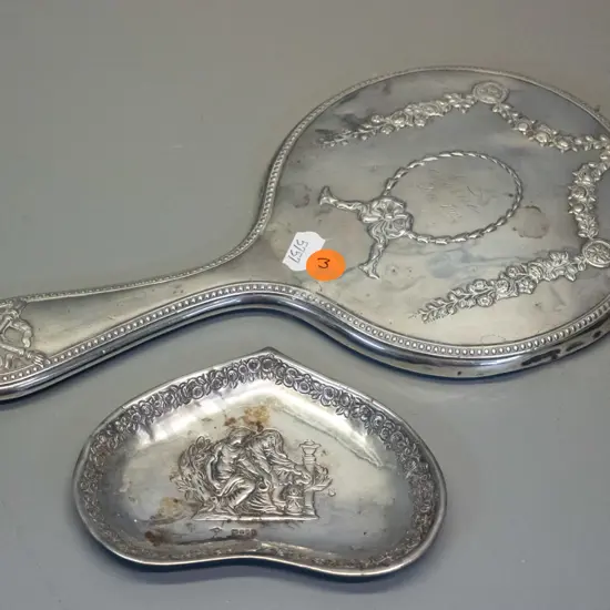 sterling silver dressing table hand mirror w/1912 inscription, and a small dish with embossed figural design