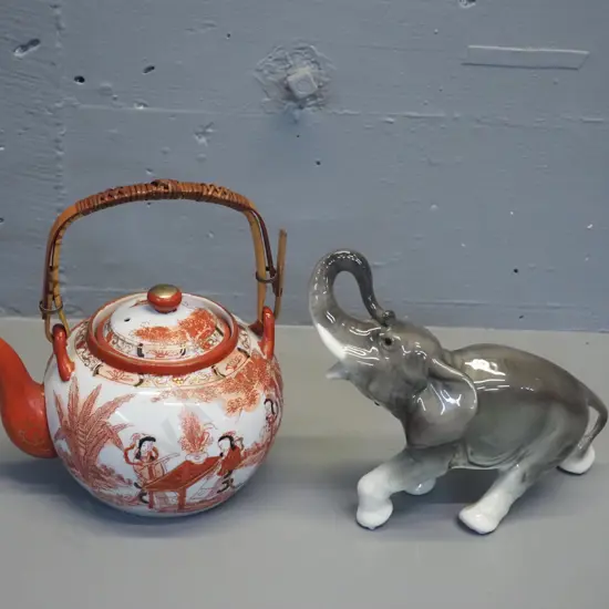 asian Kutani style teapot with strainer and cane handle, small chips to rim, and a porcelain elephant figurine H170 L200
