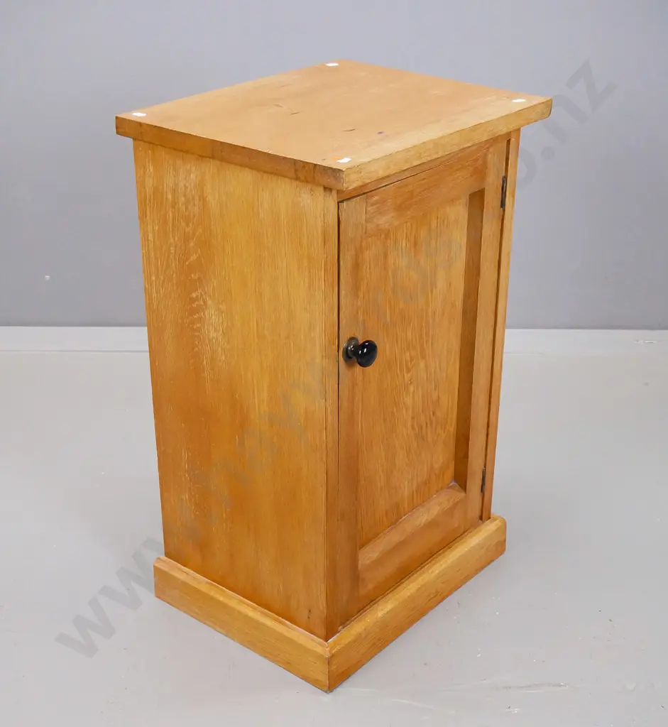 oak bedside cupboard with panelled door having black porcelain knob on plinth base Image 1++