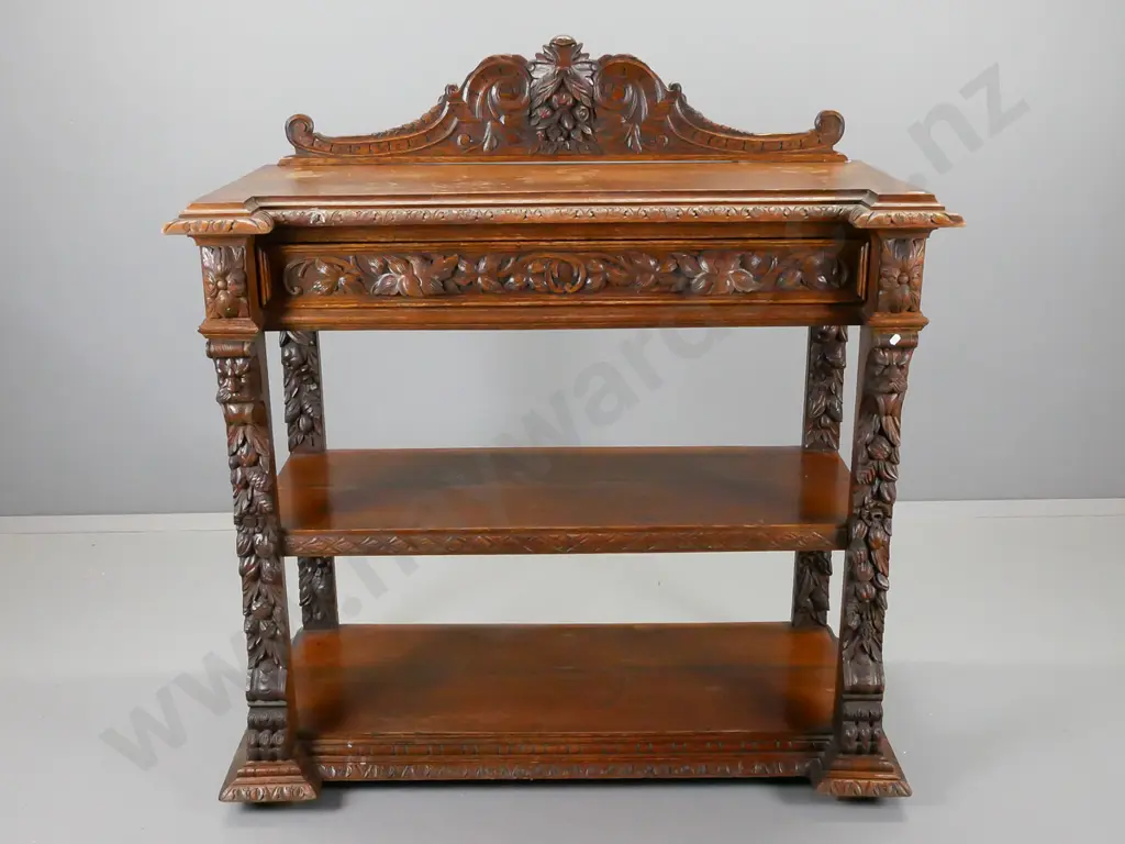 Victorian carved oak dumb waiter having foliate and floral carved crest back above a foliate carved drawer Image 1++
