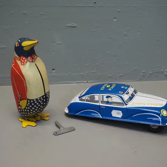 2 tin-plate toys - wind-up penguin H150, some fading, going but weak action, and a friction drive "St. John" brand