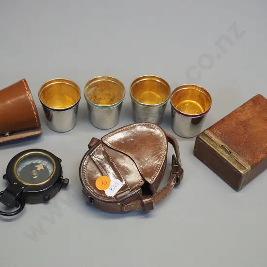 leather cased Lawrence & Mayo London prismatic service compass, a set of 4 silver plated nip cups with multi colour
