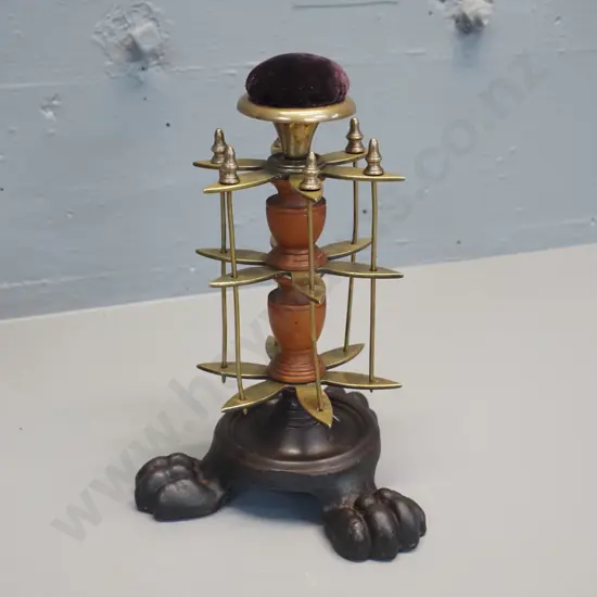 brass and timber vintage sewing stand on 3-footed cast iron base with pin cushion on top and removable thread spool