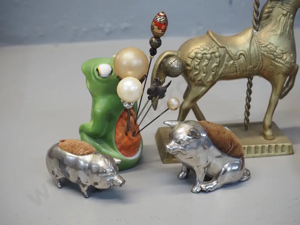 4 silver plated pin cushions, porcelain frog hat pin holder with pins and a brass carousel horse figure Image 1++