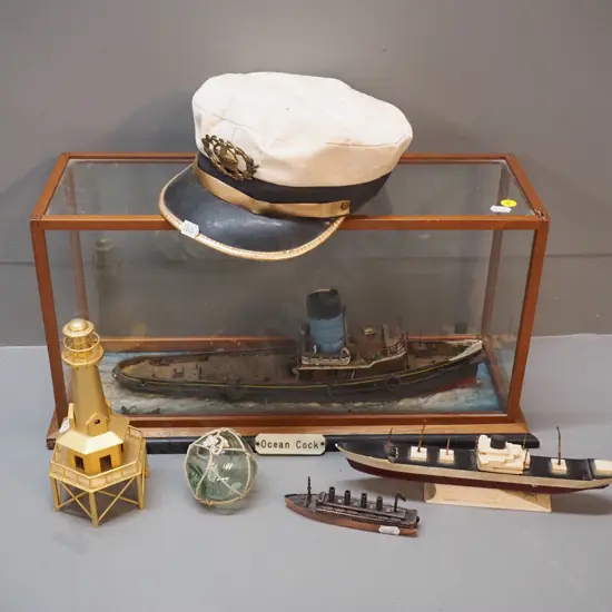 "Ocean Cock" steamer / tugboat in timber and glass case, a captain's hat, small glass float, modern brass lighthouse,