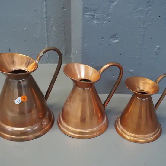 graduated set of 3 copper jugs -  marked Longbard England. Largest has a dent H-200 W-190