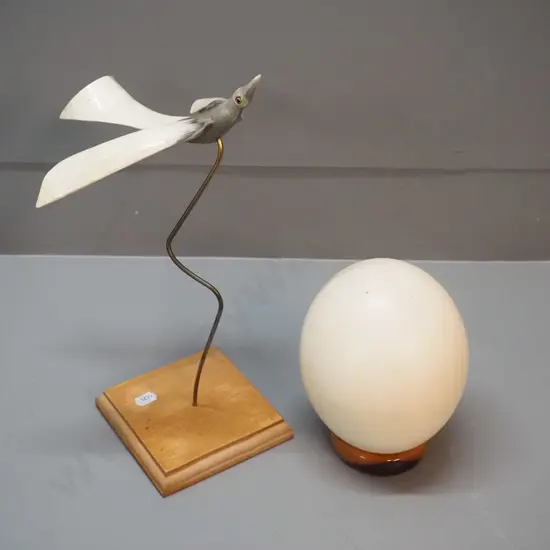 ostrich egg with wooden stand and a flying bird figure made of horn on a wooden stand H-310