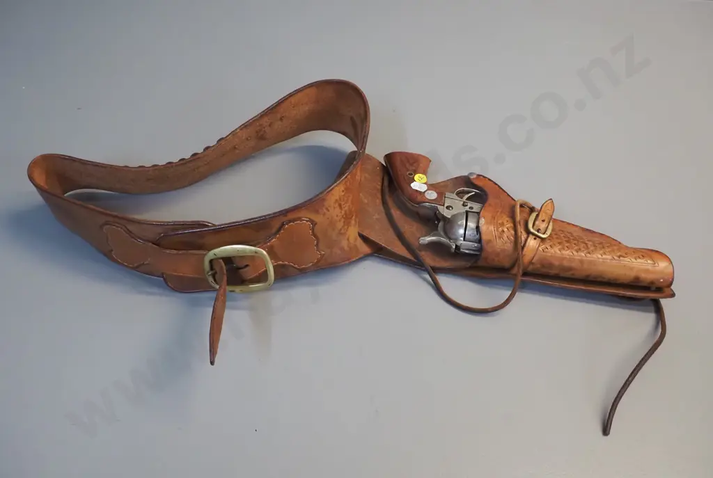 tooled leather gun belt and a vintage American style ornamental revolver. Image 1++