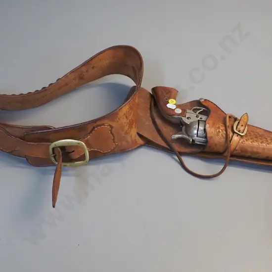 tooled leather gun belt and a vintage American style ornamental revolver.