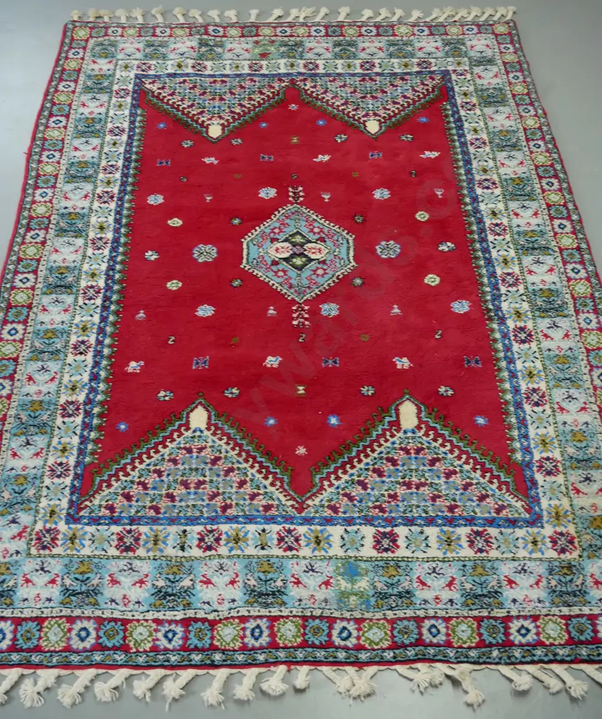 large woollen Turkish rug, red ground, central geometric medallion, multiple geometric borders in blue, red and white Image 1++