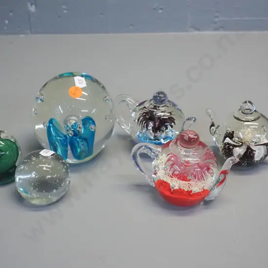 6 glass paperweights - 3 are teapot shaped "Signature Style by Murphy's" - largest paperweight H-110