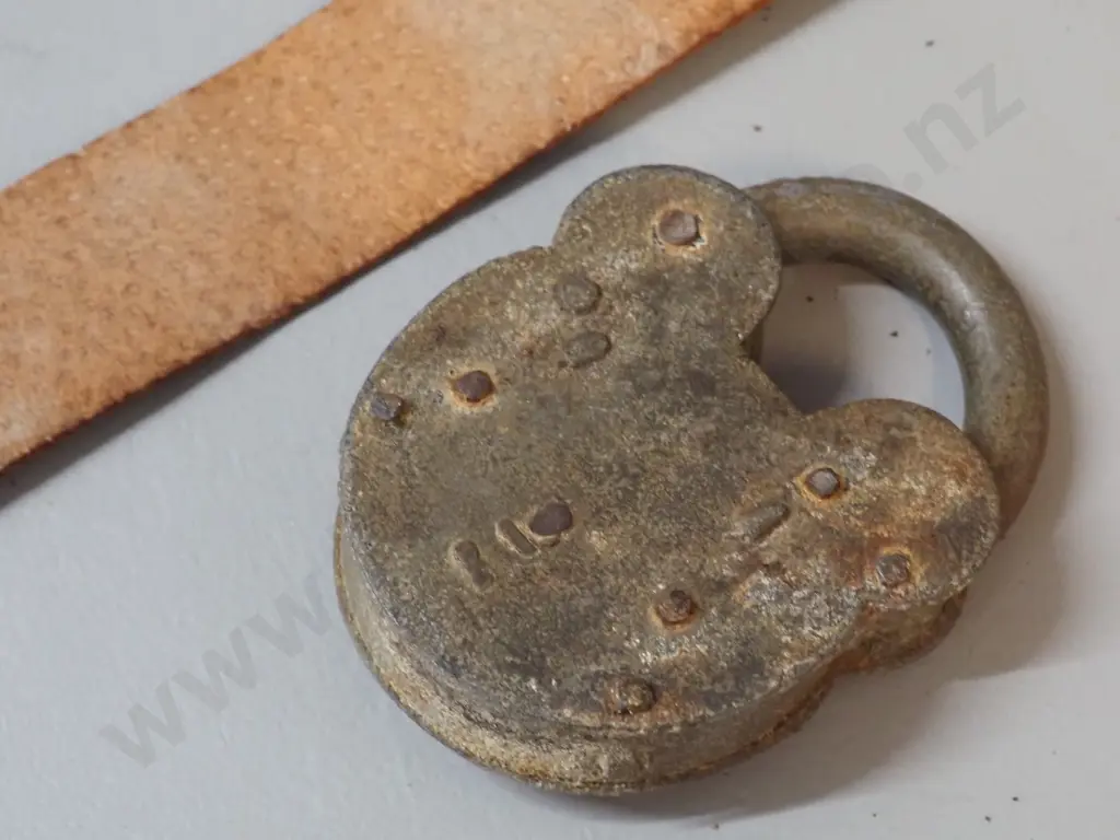 vintage padlock marked "Improved Tumbler Lock" with key on leather strap. Lock is H-100 W-70 Image 1++