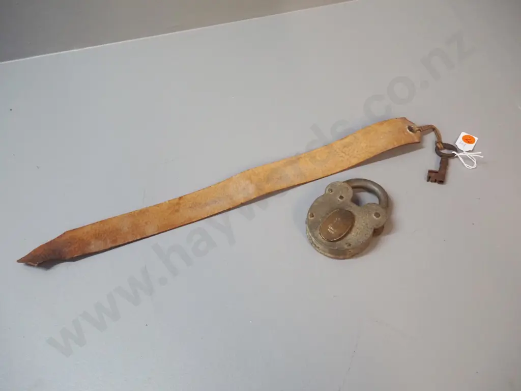 vintage padlock marked "Improved Tumbler Lock" with key on leather strap. Lock is H-100 W-70 Image 1++