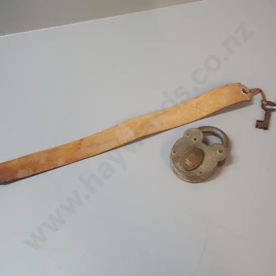 vintage padlock marked "Improved Tumbler Lock" with key on leather strap. Lock is H-100 W-70