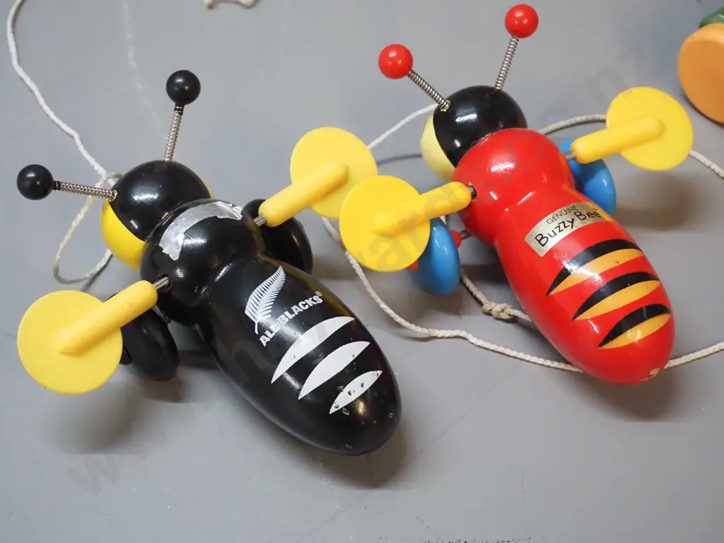3 New Zealand wooden toys: pull along kiwi bird on wheels designed by Dick Frizzell and 2 buzzy bees, one is All Blacks Image 1++