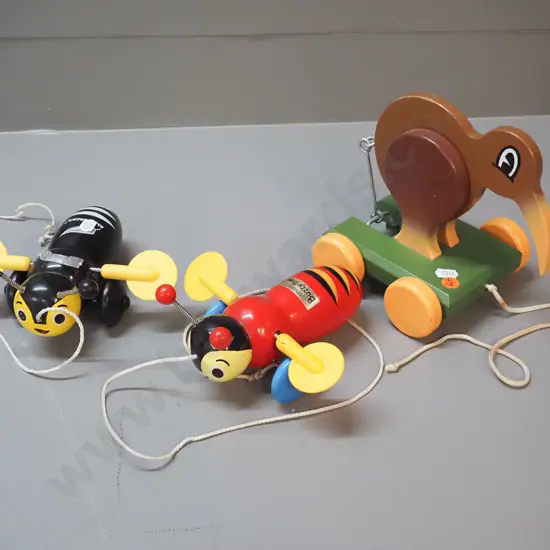 3 New Zealand wooden toys: pull along kiwi bird on wheels designed by Dick Frizzell and 2 buzzy bees, one is All Blacks