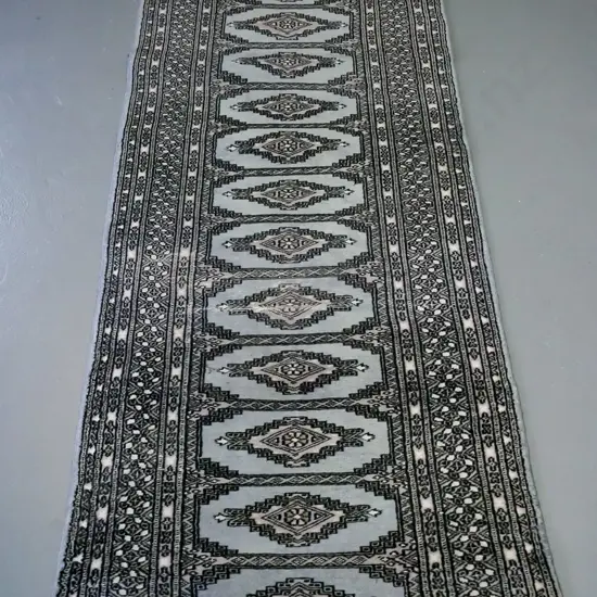 woollen handknotted runner in slate ground colour, central panels of doamond decoration,