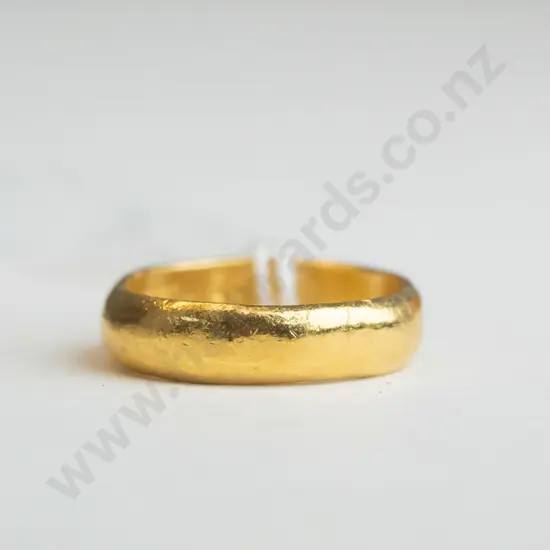 Small gold ring with writing engraved on the inner part of the ring (unreadable) 